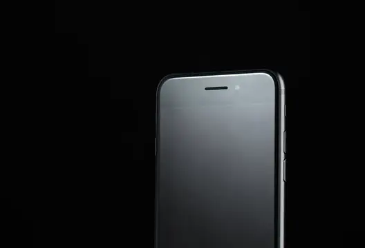 Смартфон с черным экраном на темном фоне
