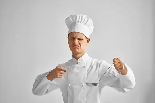 Повар-мужчина пробует блюда профессионального ресторана на вкус