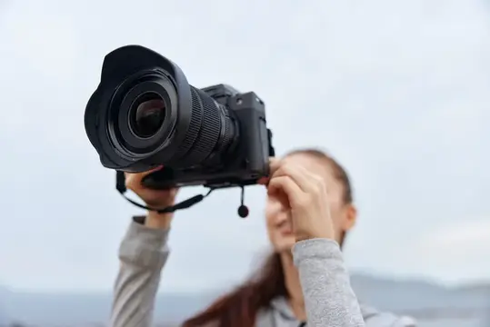 Девушка фотографирует на камеру с широкоугольным объективом