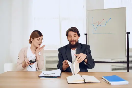 Мужчина и женщина сидят за столом, общаясь и выражая эмоции