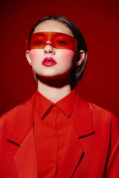 Девушка в красных очках и костюме на красном фоне