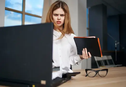 Бизнес-леди работает за столом с документами в офисе, секретарь устал
