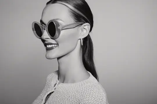 Улыбающаяся девушка в круглых солнцезащитных очках