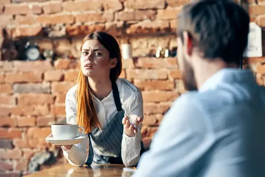 Официантка с чашкой кофе недовольно смотрит на посетителя