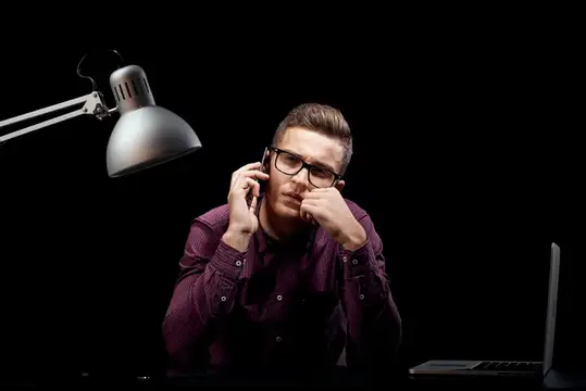 Мужчина-менеджер в помещении, темный фон, общение, красная рубашка, модель, очки, новые технологии, бизнес, финансы