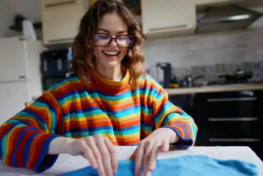 Улыбающаяся девушка в очках и полосатом свитере на кухне