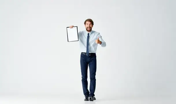 Бородатый мужчина в рубашке с галстуком работает с документами в офисе