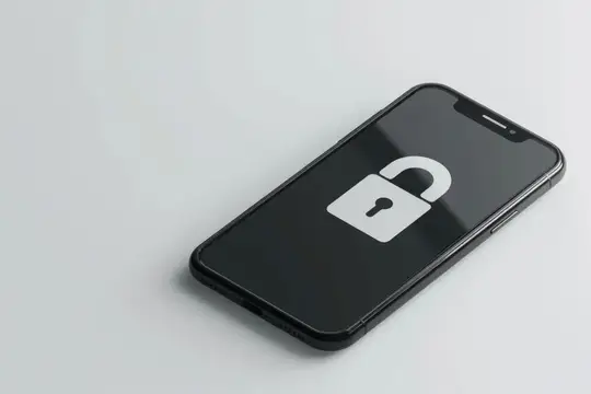 Смартфон с открытым замком на экране лежит на светлом столе