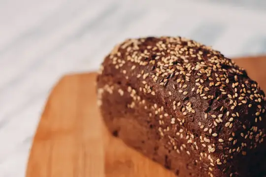 Ароматный ржаной хлеб с кунжутом на деревянной доске