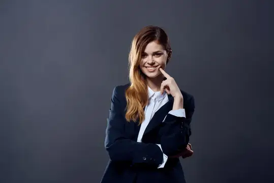 Улыбающаяся девушка в деловом костюме на тёмном фоне