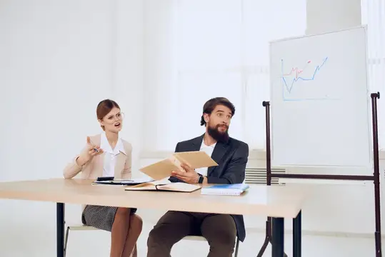 Деловые мужчины и женщины работают за столом, обмениваются сообщениями и эмоциями, как профессионалы и коллеги