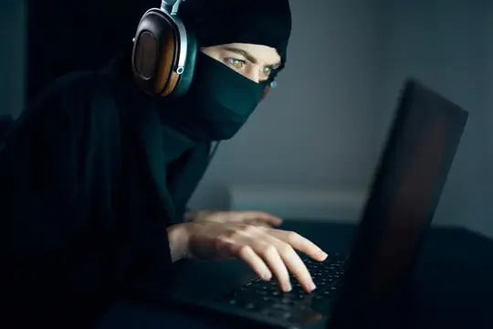 Женщина ночью сидит перед ноутбуком в наушниках, используя интернет-технологии