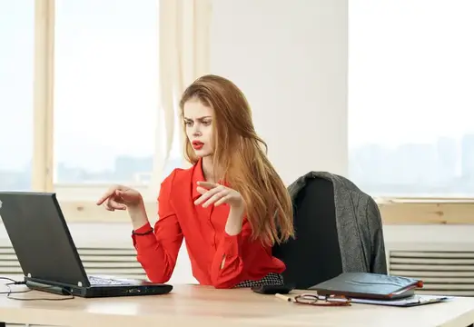 Деловая женщина работает за столом в офисе за ноутбуком в роли секретаря