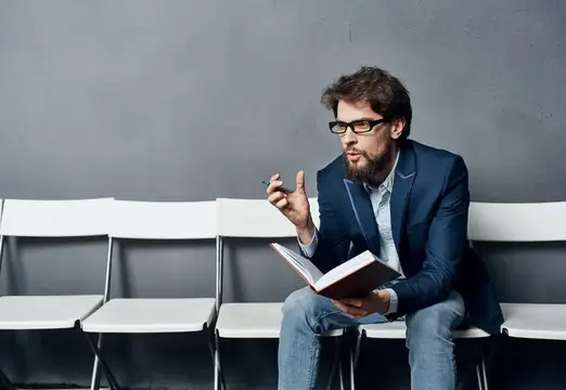 Мужчина сидит на стуле в ожидании собеседования при приеме на работу
