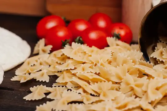 Приготовление итальянской кухни: на кухонном столе лежит мука и другие продукты