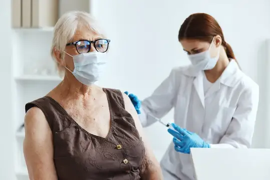 Пожилая женщина-пациентка в больнице для вакцинации и защиты иммунитета