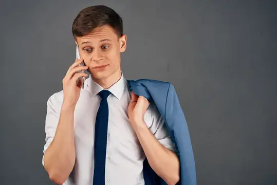 Деловой мужчина с пиджаком на плече и телефоном