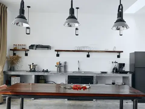Светлая кухня в стиле лофт с деревянным столом и чёрными лампами