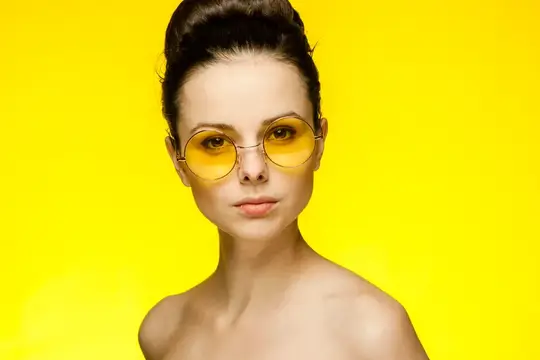 Женщина с обнаженными плечами, в желтых очках и с собранными волосами