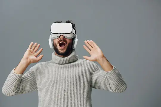 Бородатый мужчина в VR-очках в восторге вскинул руки
