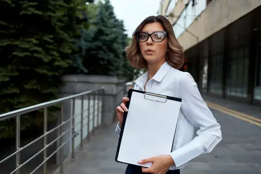Девушка в очках с планшетом на городской улице