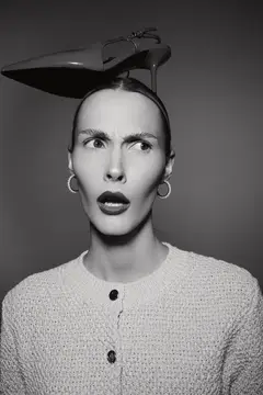 Удивлённая женщина с туфлей на голове