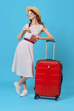 Молодая женщина в шляпе с красным чемоданом на голубом фоне