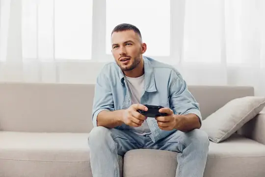 Сосредоточенный мужчина наслаждается захватывающей игровой сессией в светлой просторной гостиной