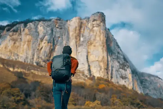Женщина-туристка в горах среди каменистых скал