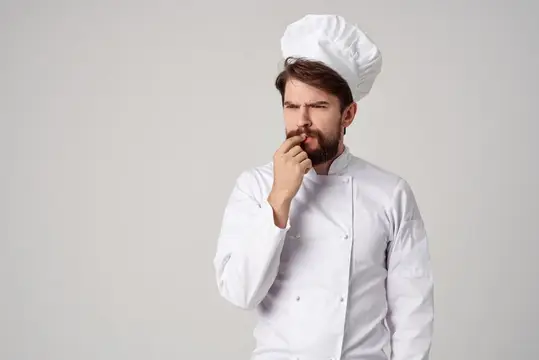 Мужчина-повар, ресторанный сервис, профессиональный жест рукой, позирование в студии