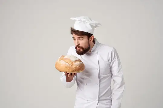 Повар на кухне, работа с хлебобулочными изделиями на светлом фоне