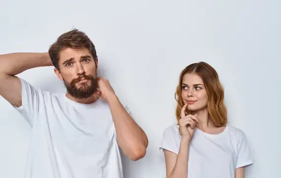 Красивая женщина и молодой человек в одинаковых футболках на светлом фоне жестикулируют