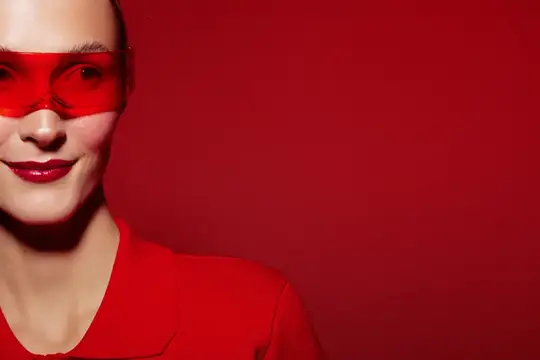 Улыбающаяся женщина в красных очках на красном фоне