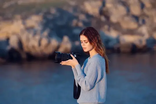 Женщина-туристка с фотоаппаратом на фоне скалистых гор, путешествие, профессионалы