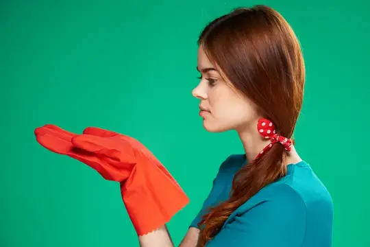 Молодая женщина с красной резиновой перчаткой на зелёном фоне