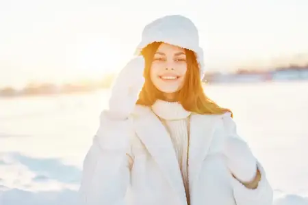Женщина позирует на фоне зимней погоды и снега, отдыхая на природе