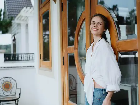 Женщина на балконе дома с телефоном, красивая улыбка в выходной день, прекрасный вид на природу в горах, образ жизни, отдых в отеле