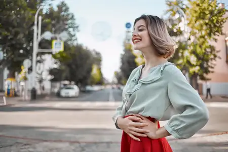 Жизнерадостная блондинка прогуливается по городу, наслаждаясь образом жизни