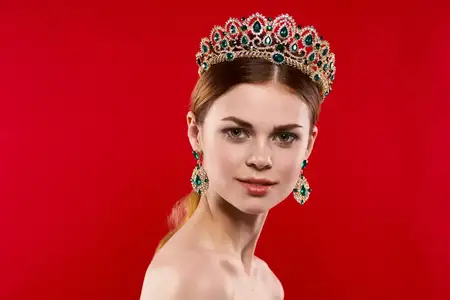 Привлекательная женщина с обнаженными плечами, украшения, косметика, позирует в студии