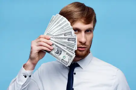 Деловой мужчина в рубашке с галстуком держит пачку денег