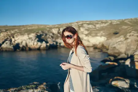 Женщина в горах на пляже у реки с прозрачной водой