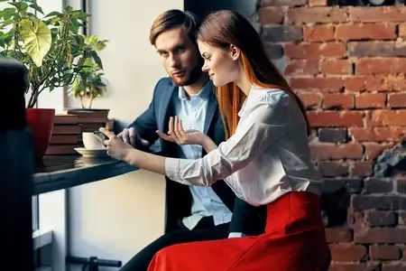 Мужчина и женщина сидят в кафе, общаются, ведут деловой образ жизни