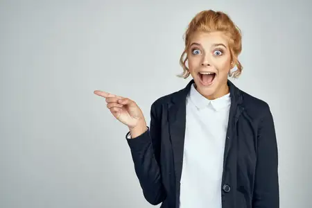 Красивая женщина в костюме жестикулирует руками на светлом фоне