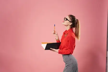 Деловая женщина в офисном костюме менеджера работает на фоне розового цвета