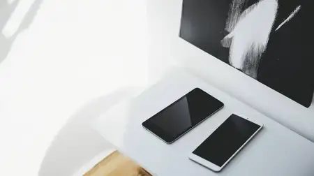Современные смартфоны, выставленные на гладком столе, подчеркивают технологии и минималистичный образ жизни