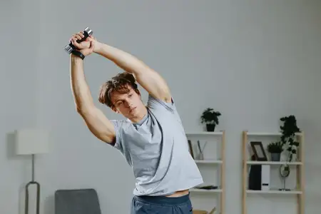 Активный молодой мужчина в спортивной одежде занимается спортом дома