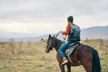 Женщина-туристка едет верхом на лошади, путешествие по горному пейзажу
