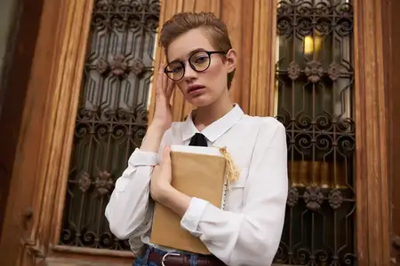 Студент на улице возле здания отдыхает