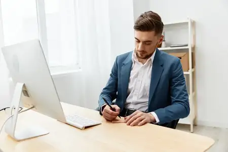 Менеджер работает за компьютером на рабочем столе, излучая уверенность в себе