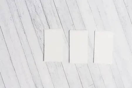 Белые визитки на деревянном фоне, фирменные бланки, вид сверху